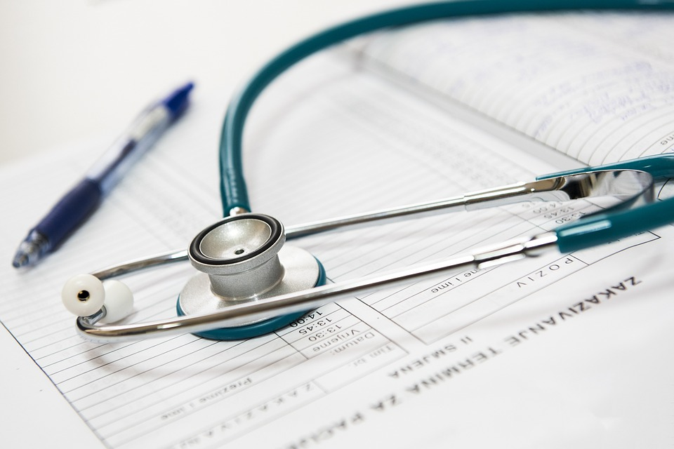 A stethoscope and pen sit on paperwork